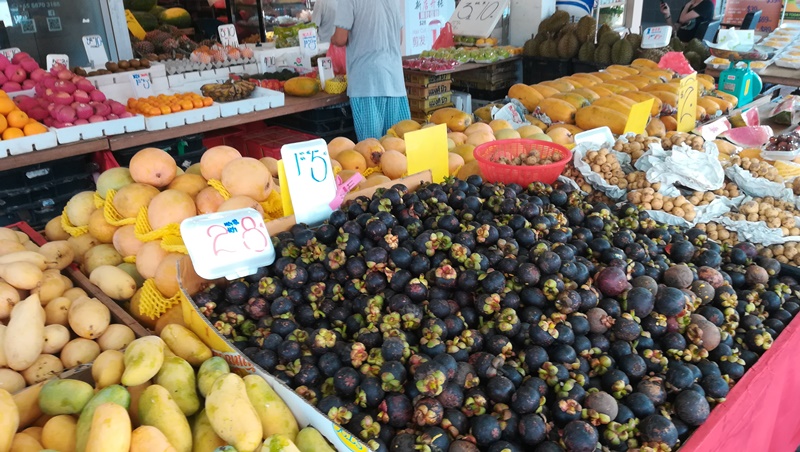 シンガポールの市場の果物屋でマンゴーやロンガンと一緒に売られている量り売りのマンゴスチンの山
